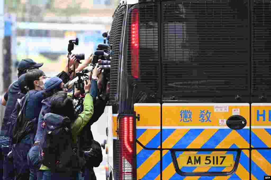 Members of the media surround a correctional services bus purportedly carrying pro-democracy activists Agnes Chow, Ivan Lam and Joshua Wong as it leaves the court in Hong Kong after the three pleaded guilty to inciting a rally during pro-democracy protests in 2019.