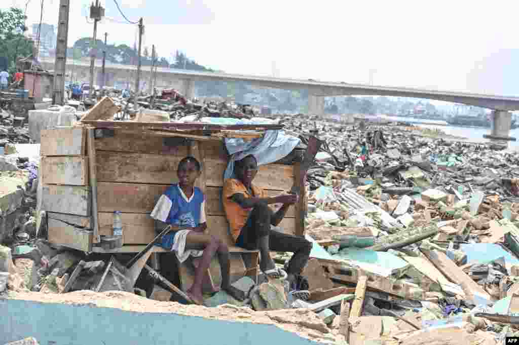 Residents sit near a structure amid rubbles of demolished houses in Boribana, district of Attecoube in Abidjan, Ivory Coast. The governor of the district of Abidjan begun an operation to demolish high-risk neighborhoods in the city. 