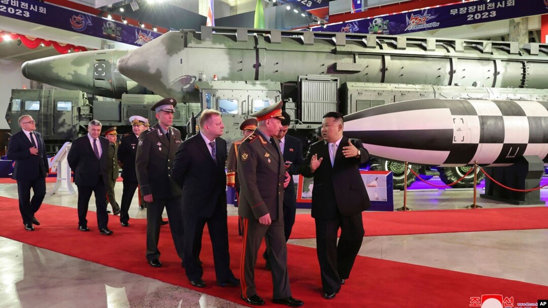 In this photo provided by the North Korean government, North Korean leader Kim Jong Un, right, leads a Russian delegation headed by Defense Minister Sergei Shoigu through an arms exhibition in Pyongyang, July 26, 2023.