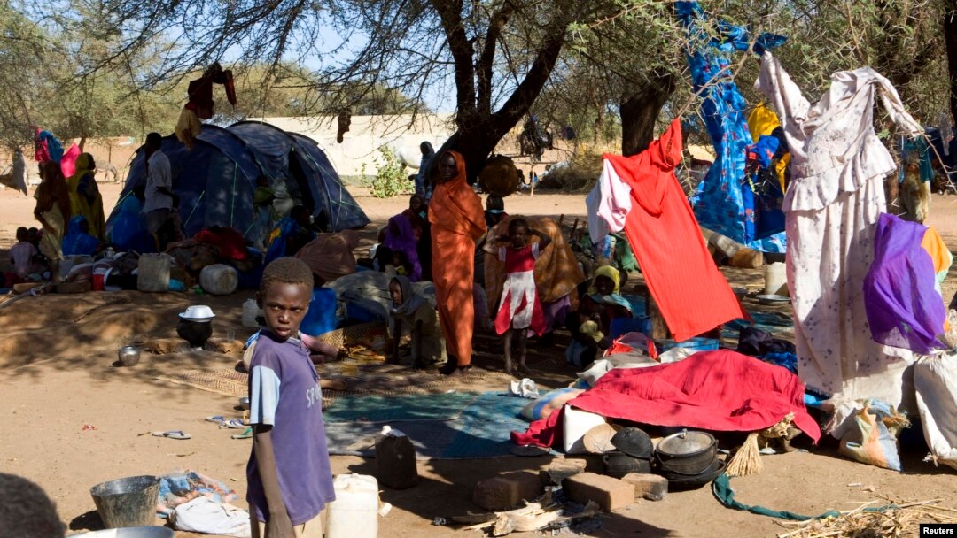 FILE - Families displaced in Muhajiriya, sit at Zamzam IDP camp in North Darfur.