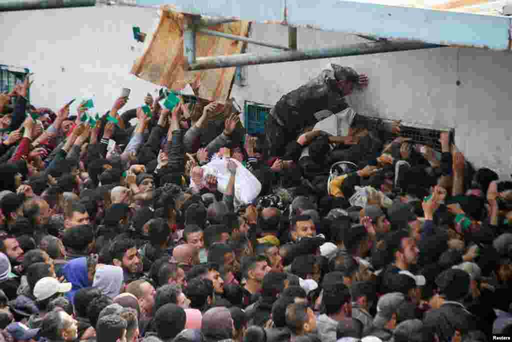 Palestinians gather to receive aid outside an UNRWA warehouse as Gaza residents face crisis levels of hunger, amid the ongoing conflict between Israel and Hamas, in Gaza City.