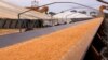 FILE - A belt carries wheat grains towards a silo for loading into a train at the town of Mallala, located north of Adelaide, South Australia, Aug. 20, 2018. 