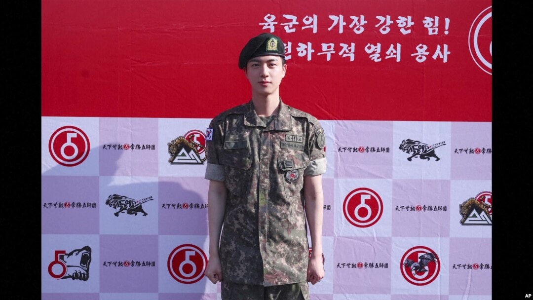 Manm gwoup K-Pop BTS la, Jin, poze pou yon foto apre li fini sevis milite li nan Lame Kore di Sid, 12 Jyen 2024. 