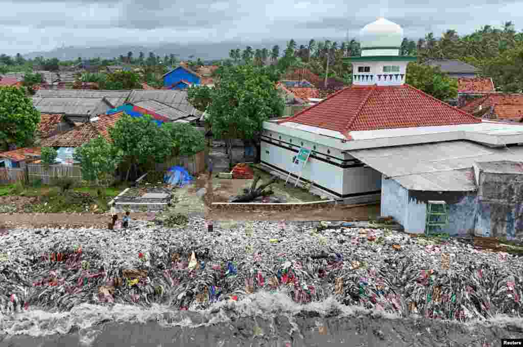 A drone view shows trash being swept to the shore due to high tides caused by erratic weather, on a beach in Teluk fishing village, in Pandeglang regency, Banten province, Indonesia.