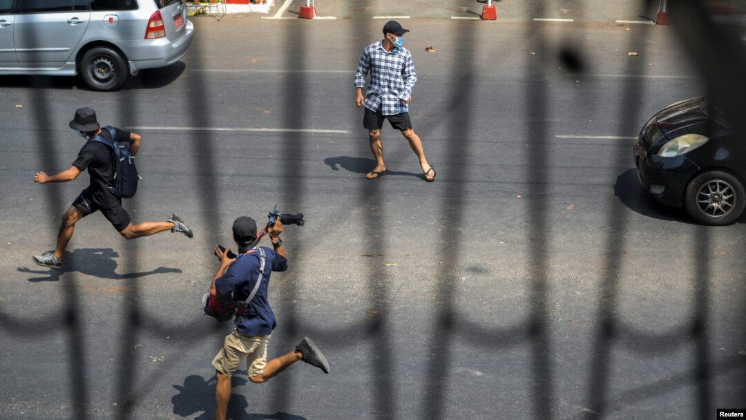 ရန်ကုန်မြို့ စစ်အာဏာသိမ်းဆန့်ကျင် ဆန္ဒပြပွဲတခုအတွင်း အပြေးအလွှားသတင်းယူနေတဲ့ သတင်းထောက်တဦးကို တွေ့ရစဉ် (ဖေဖော်ဝါရီ ၂၇၊ ၂၀၂၁)