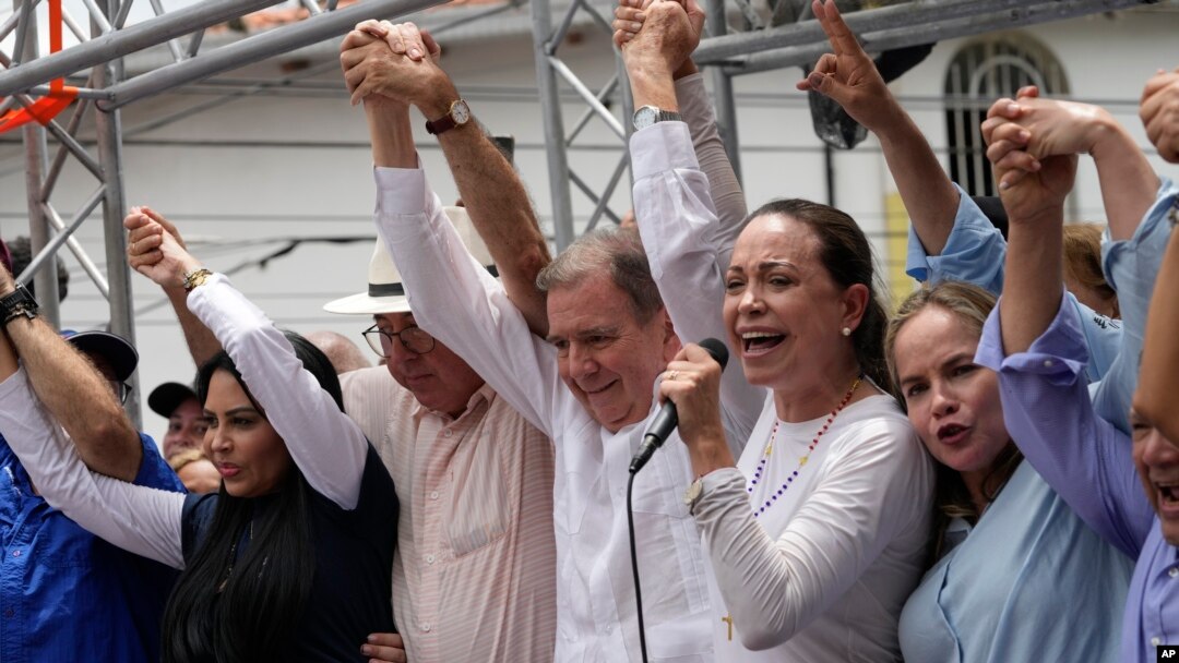 Venezuelan presidential candidate Edmundo Gonzalez Urrutia, center, and opposition leader Mariana Corina Machado, second right, attend the launch of his campaign for the upcoming election in La Victoria, Venezuela, May 18, 2024. 