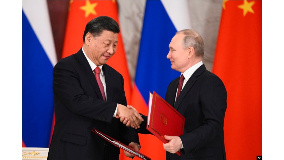 FILE - Russian President Vladimir Putin, right, and Chinese President Xi Jinping shake hands as they exchange documents during a signing ceremony following their talks at the Grand Kremlin Palace, in Moscow, Russia, March 21, 2023.