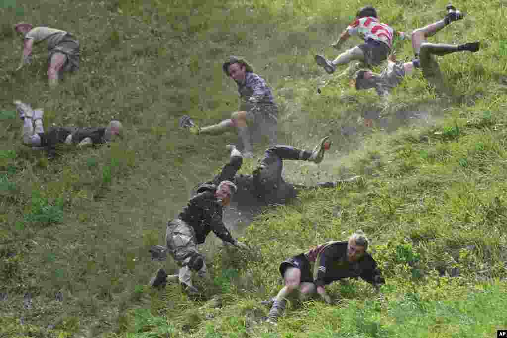 Participants compete in the men's downhill race during the Cheese Rolling contest at Cooper's Hill in Brockworth, Gloucestershire.