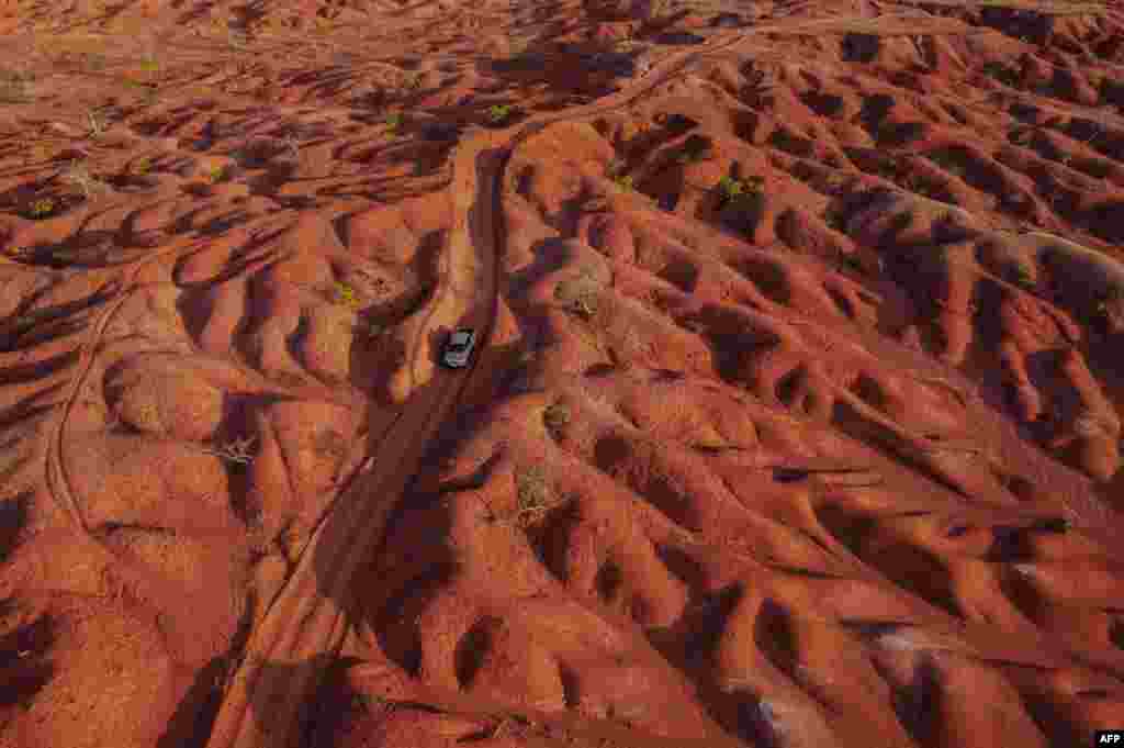 Aerial view showing a car riding along a dirt road in the Desert of Gilbues, in Gilbues, in the northeastern state of Piaui, Brazil, Sept, 30, 2023. Gilbues is Brazil's worst desertification hotspot, where a parched, canyon-pocked landscape is swallowing up farms and residences. Experts say the phenomenon is caused by rampant erosion of the region's naturally fragile soil, exacerbated by deforestation, reckless development and probably climate change.