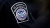 FILE - A customs agent wears a patch for the U.S. Customs and Border Protection agency at John F. Kennedy International Airport in New York, Oct. 27, 2017.