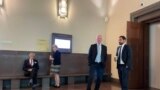 سمت راست تصویز: وکیل متهم و وکیل شاکیان در کنار هم درپشت درهای بسته سالن ۳۷ در انتظار شروع مجددجلسه.  سمت چپ: دو وکیل دیگر شاکیان پرونده. در مجموع دو وکیل وظیفه دفاع از حمید نوری و چهار وکیل وظیفه دفاع از  شاکیان این پرونده را برعهده دارند.