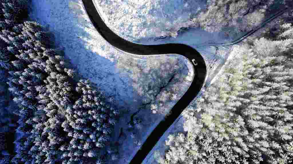 A car passes snow-covered trees at the &#39;Harz&#39; mountains near Wernigerode, Germany.