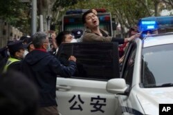 上海警察逮捕了一名抗议中国严厉防疫政策的青年。（2022年11月27日）