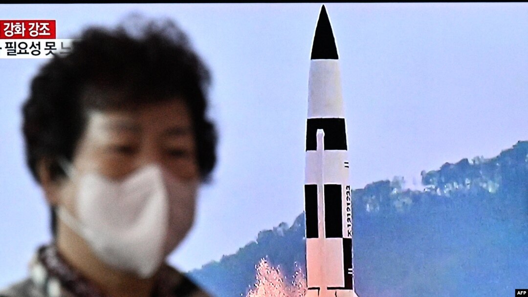 FILE - A woman walks past a television showing a news broadcast with a photo of a Hokkaido missile launch training test by the North Korean People's Army Tactical Nuclear Operation Unit, at a railway station in Seoul, South Korea, Oct. 10, 2022.