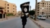 ISIS အကြမ်းဖက်အဖွဲ့ဝင်နဲ့ IS အလံ (REUTERS/Stringer)