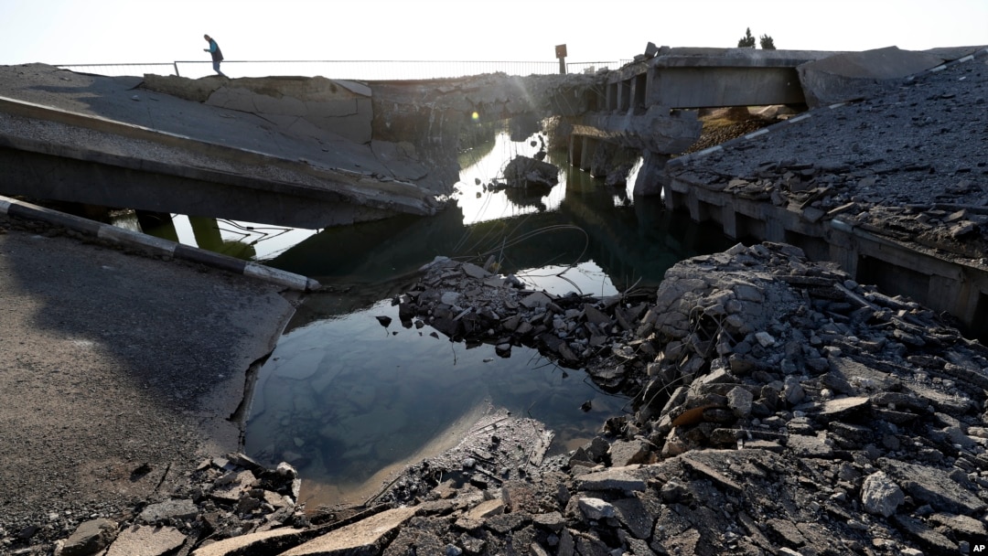 A man passes by a bridge that links Lebanon to Syria, in Qusair, Syria, Oct. 27, 2024. The bridge was destroyed by an Israeli airstrike on Oct. 24, 2024.