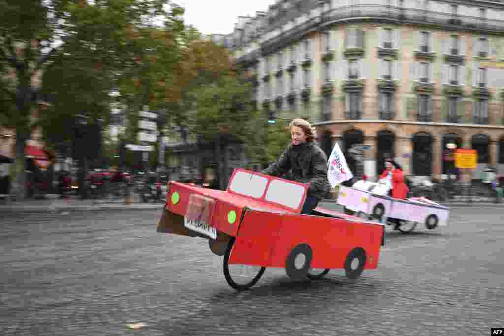 People ride a cardboard car on Place de la Bastille during a 'car free' day in Paris, France.