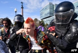 Riot police officers detain a man during an unsanctioned rally urging fair elections in downtown Moscow on August 3, 2019.