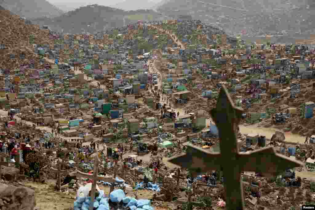 People visit tombs of relatives and friends at 'Nueva Esperanza' (New Hope) cemetery during the Day of the Dead celebrations in Villa Maria del Triunfo on the outskirts of Lima, Peru, Nov. 1, 2017.