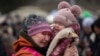 A woman holding a child cries after fleeing from the Ukraine and arriving at the border crossing in Medyka, Poland, March 7, 2022.