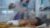 FILE - A nurse takes care of a baby in the neonatal intensive care unit of Malalai Maternity Hospital in Kabul, Afghanistan, Dec. 9, 2021.