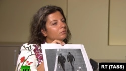 RT Editor-in-Chief Margarita Simonyan shows an image of two men during an interview with Anatoliy Chepiga (aka Ruslan Boshirov) and Dr. Alexander Mishkin (aka Alexander Petrov), suspected of poisoning former GRU officer Sergei Skripal and his daughter Yulia in Salisbury, England.