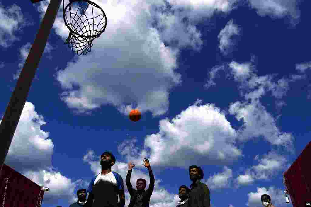 Migrants play basketball on the deck of Spanish NGO Open Arms lifeguard ship as they wait to get off the ship after docking at Messina port, in Sicily, Italy. More than 400 migrants from Egypt, Syria, Pakistan Bangladesh, Eritrea, Sudan, Ethiopia, and Somalia were rescued by NGO Open Arms crew members. 