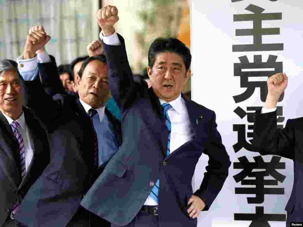 Japan's Prime Minister Shinzo Abe (3rd L) and his party's lawmakers raise their fists as they pledge to win in the upcoming lower house election, at their party headquarters in Tokyo.