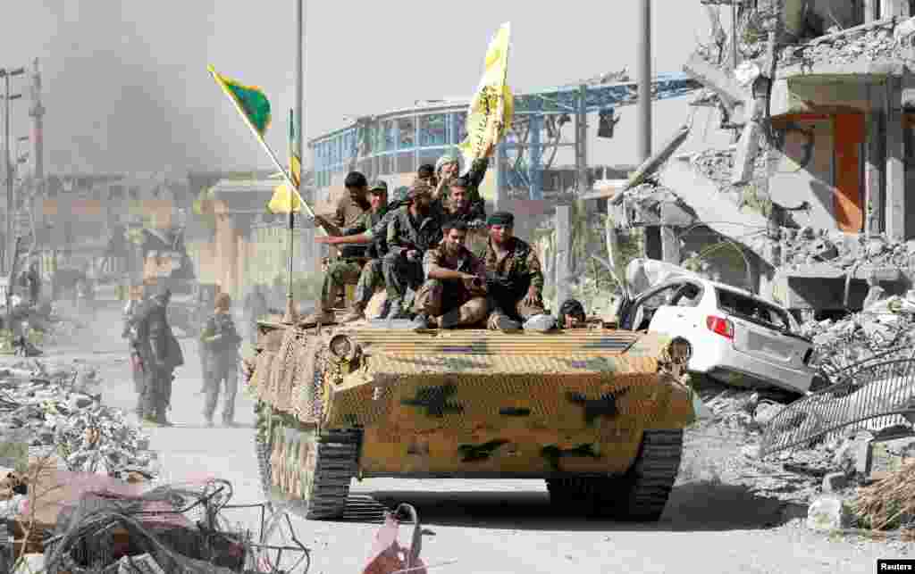 Syrian Democratic Forces (SDF) fighters ride atop of military vehicle in Raqqa as they celebrate victory and liberation of Raqqa from the Islamic State militants.