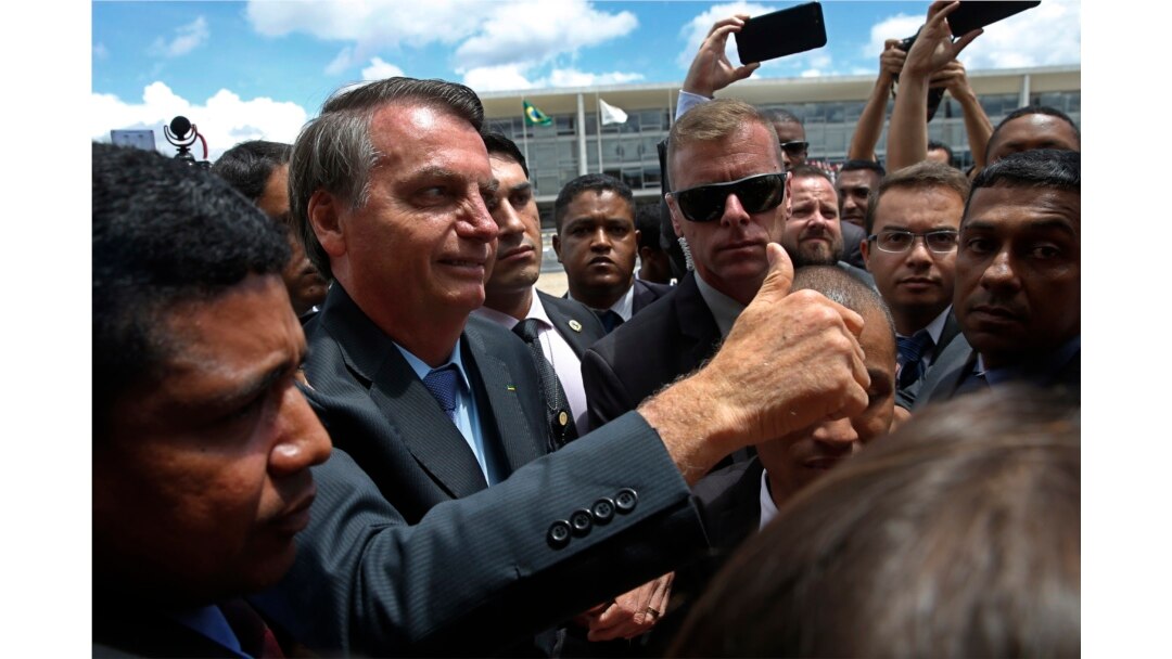 FILE - Brazil's President Jair Bolsonaro greets supporters after attending a Changing of the Guard at the Planalto Presidential Palace, in Brasilia, Nov. 28, 2019.