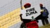FILE - Supporters of various opposition parties hold placards calling for the removal of President Jacob Zuma outside the Constitutional Court in Johannesburg, South Africa, May 15, 2017.