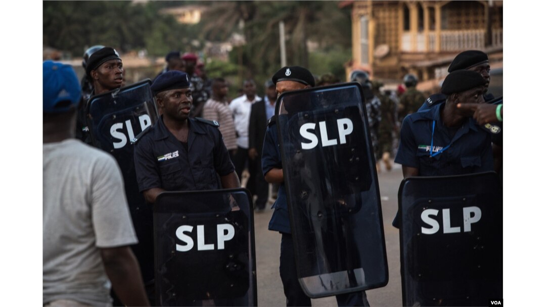 Police hold shields following running battles with supporters of the opposition Sierra Leone People's Party in the Goderich neighborhood of Freetown, Sierra Leone, March 7, 2018. (J. Patinkin/VOA)