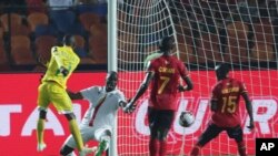 Mchezaji wa Zimbabwe Khama Billiat, kushoto, akifunga goli la kifungua dimba wakati timu ya Uganda na Zimbabwe katika kundi A zilipopambana katika michuano ya AFCON, Jumatano, Juni 26, 2019. (AP Photo/Hassan Ammar)