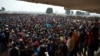 People wait to receive food and supplies from an aid distribution point set up inside a makeshift camp at Mpoko Airport in Bangui, Jan. 7, 2014.