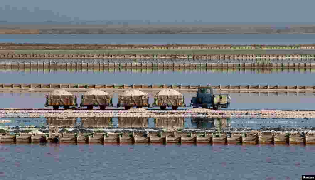 A train drives across the bed of a drained area of a lake used for the production of salt at the Sasyk-Sivash lake near the city of Yevpatoria, Crimea, Nov. 14, 2017.