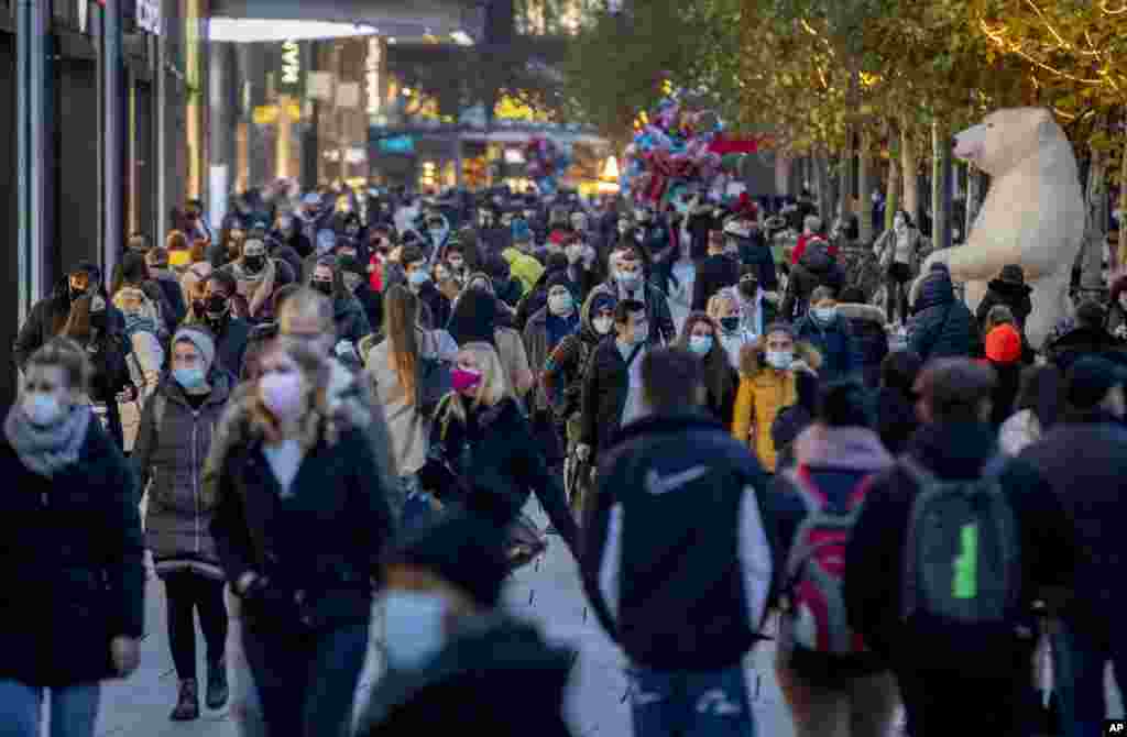 People walk in the main pedestrian zone in Frankfurt, Germany. The government is calling on citizens to forgo Christmas shopping two days before the country heads into a hard lockdown that will shut most stores, tighten social distancing rules and close schools. 