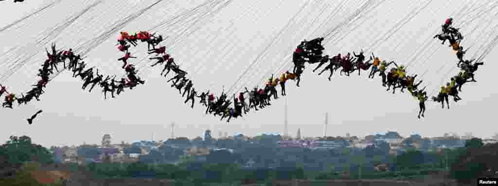 People jump off a bridge, which has a height of 30 meters, in Hortolandia, Brazil, Oct. 22, 2017. According to organizers, 245 people were attempting set a new world record for "rope jumping", in which people, tied to a safety cord, jump off a bridge.