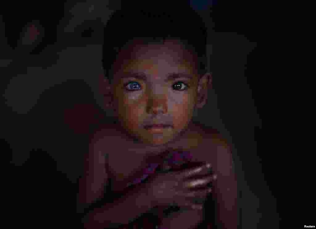 Hosne Ara, 4, a Rohingya refugee who fled Myanmar two-months ago listens to children singing at a children's center in the Kutupalong refugee camp near Cox's Bazar, Bangladesh.
