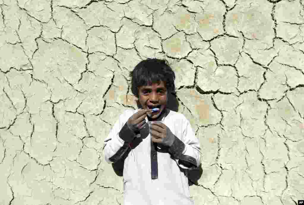 An Afghan internally displaced boy eats ice cream near his home on the outskirts of Kabul, Afghanistan.