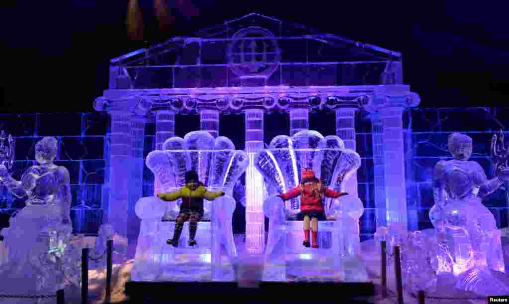 Jack Drury and Ruby Darragh sit on ice sculptures at the launch of Hyde Park Winter Wonderland's Magical Ice Kingdom in London.