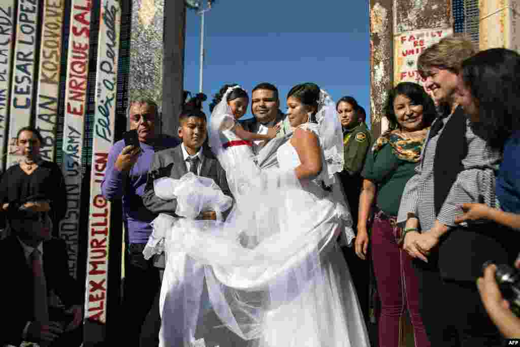 Bride Evelia Reyes and groom Brian Houston, living on different sides of the U.S.-Mexico border, stand for a family portrait after getting married during the "Opening the Door of Hope" event at the border fence gate in Playas de Tijuana, Mexico, Nov. 18, 2017