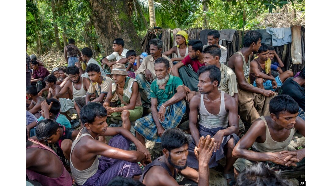 FILE - Rohingya Muslims from Myanmar wait to carry food items from Bangladesh's border toward a no man's land where they set up refugee camps in Tombru, Bangladesh, Sept. 15, 2017.