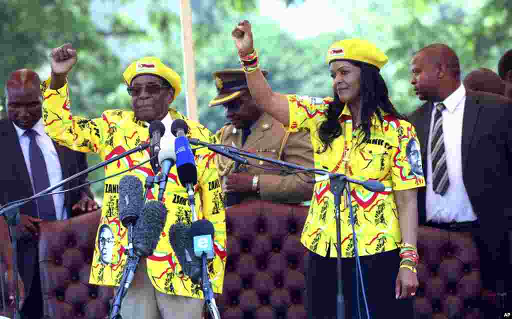 Zimbabwe's President Robert Mugabe, left, and his wife Grace chant the party's slogan during a solidarity rally in Harare.