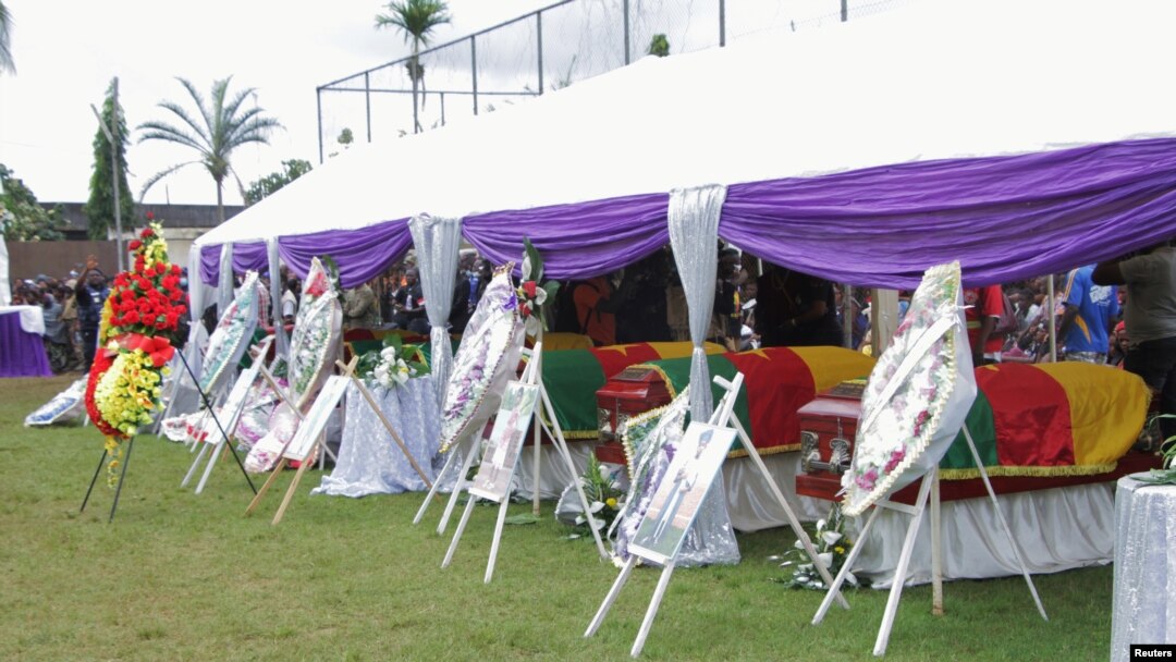 Flag-draped caskets of seven children who were killed by unidentified assailants in a classroom of a secondary school are pictured during their mass funeral in Kumba, Cameroon, Nov. 5, 2020.
