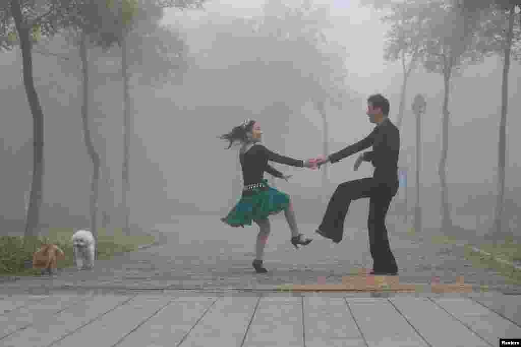 People dance in a park on a foggy day in Huai'an, Jiangsu province, China.