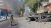 A Somali soldier stands near the burnt wreckage of a car, after an explosion, in Mogadishu Somalia, Oct. 1, 2016.