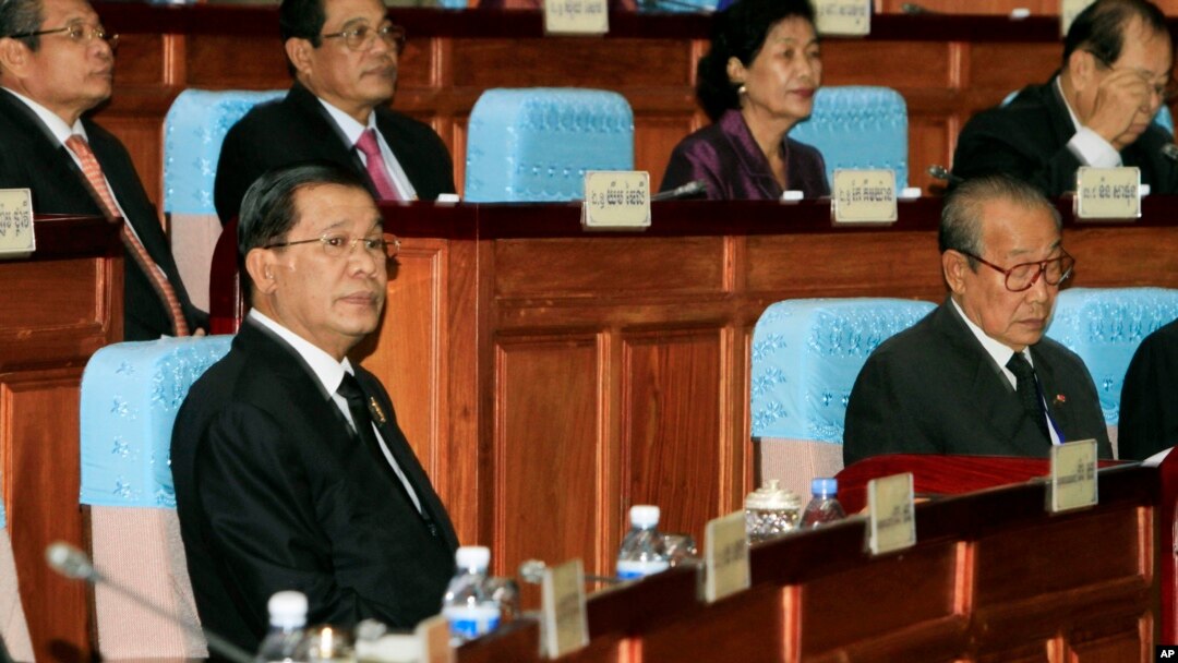Cambodian Prime Minister Hun Sen, left, sits inside the session hall of the National Assembly with lawmakers from his Cambodian People's Party, in Phnom Penh, Cambodia, Sept. 24, 2013.