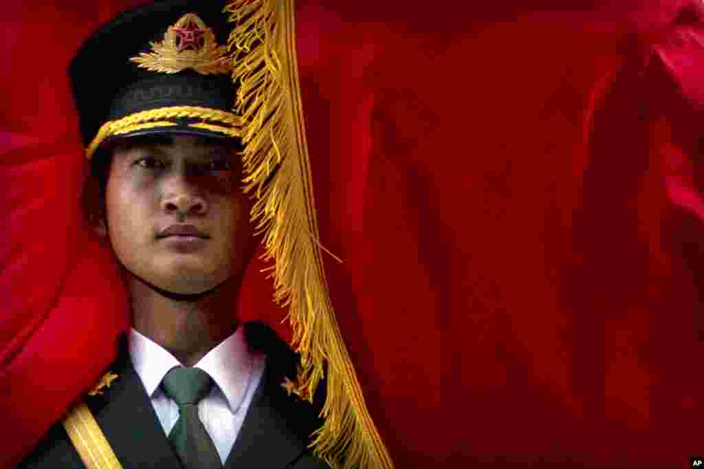 The wind blows a flag around a Chinese honor guard member before a welcome ceremony for Panamanian President Juan Carlos Varela at the Great Hall of the People in Beijing.