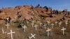 FILE - Members of South Africa's mining community walk near crosses placed at a hill where 43 miners died during clashes with police in 2012 at Lonmin's Marikana platinum mine in Rustenburg, northwest of Johannesburg, May 14, 2013.