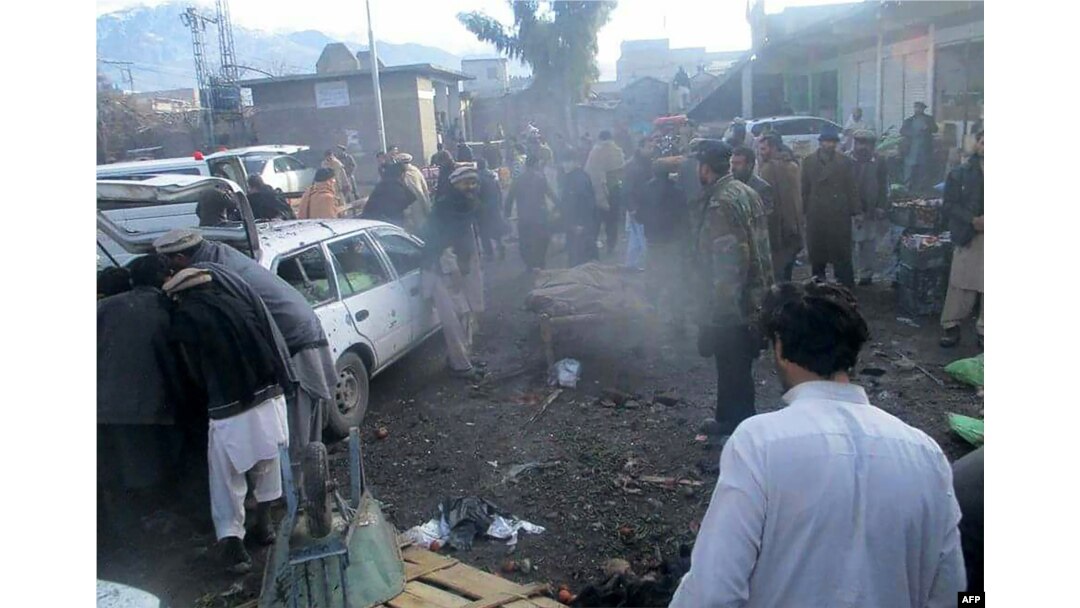 Pakistani security officals and local residents are seen gathered at the site of a bomb explosion at a market in Parachinar city, the capital of Kurram tribal district on the Afghan border on Jan. 21, 2017.